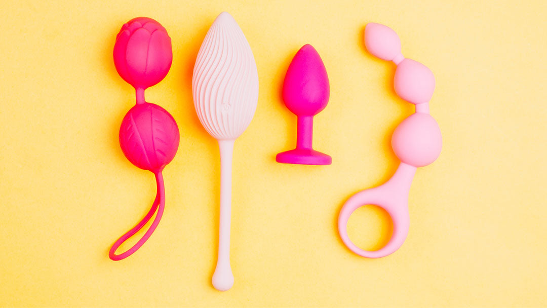 Image of pink silicone sex toys against a light yellow background