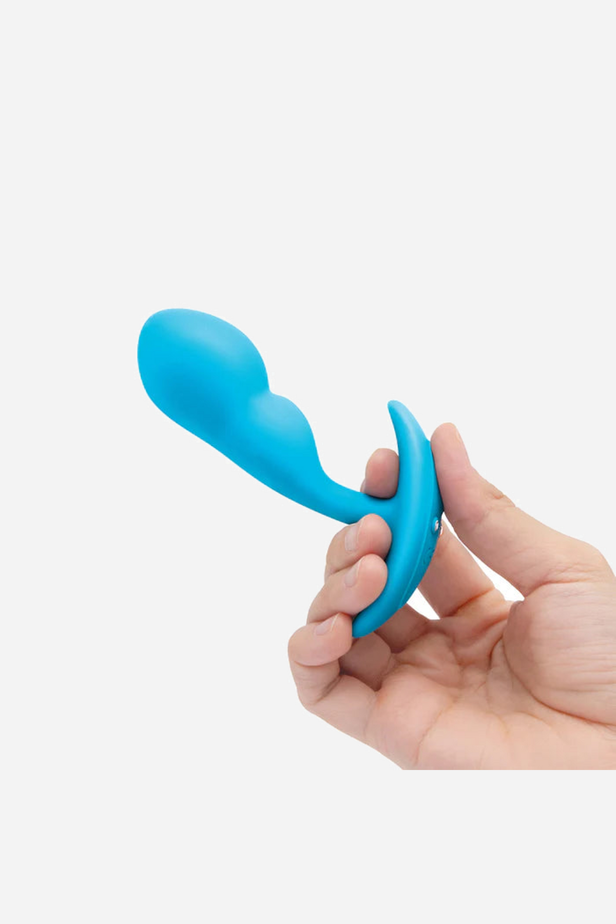 A hand pinching the teal plug by its flared base, with the tip pointing upward