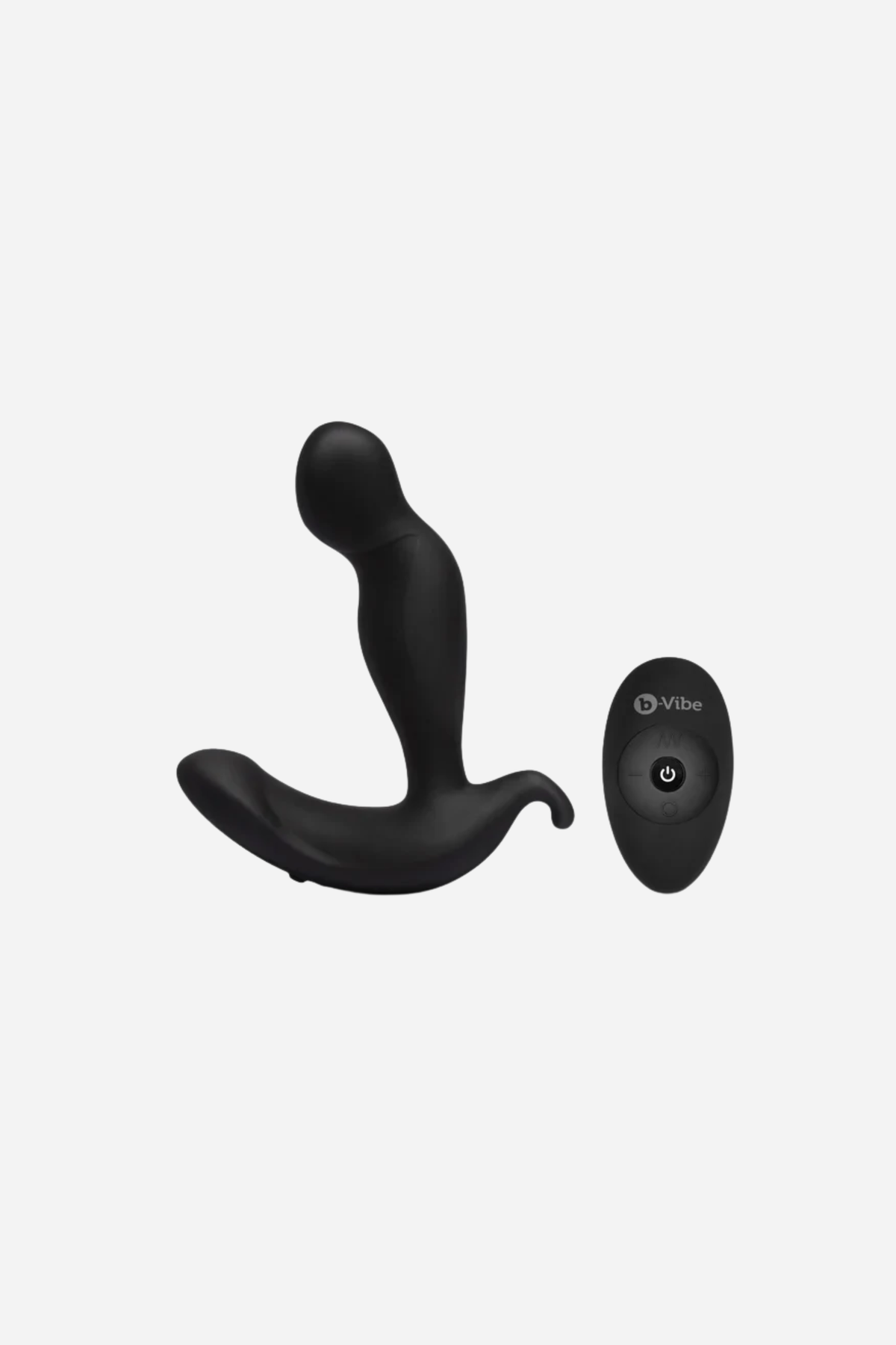 B-Vibe 360 rotating and vibrating plug in black with its wireless remote, a curved silicone prostate massager with a perineum base, on grey