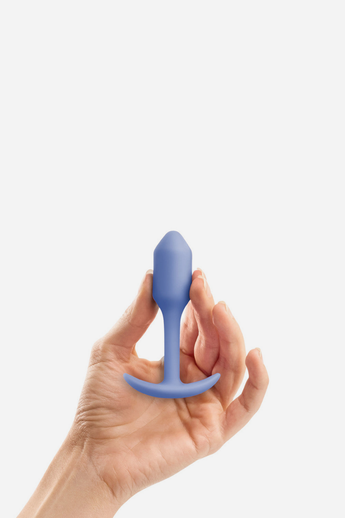Hand holding the lilac B-Vibe Snug Plug 1 small weighted butt plug between the fingers to show its compact, beginner-friendly size