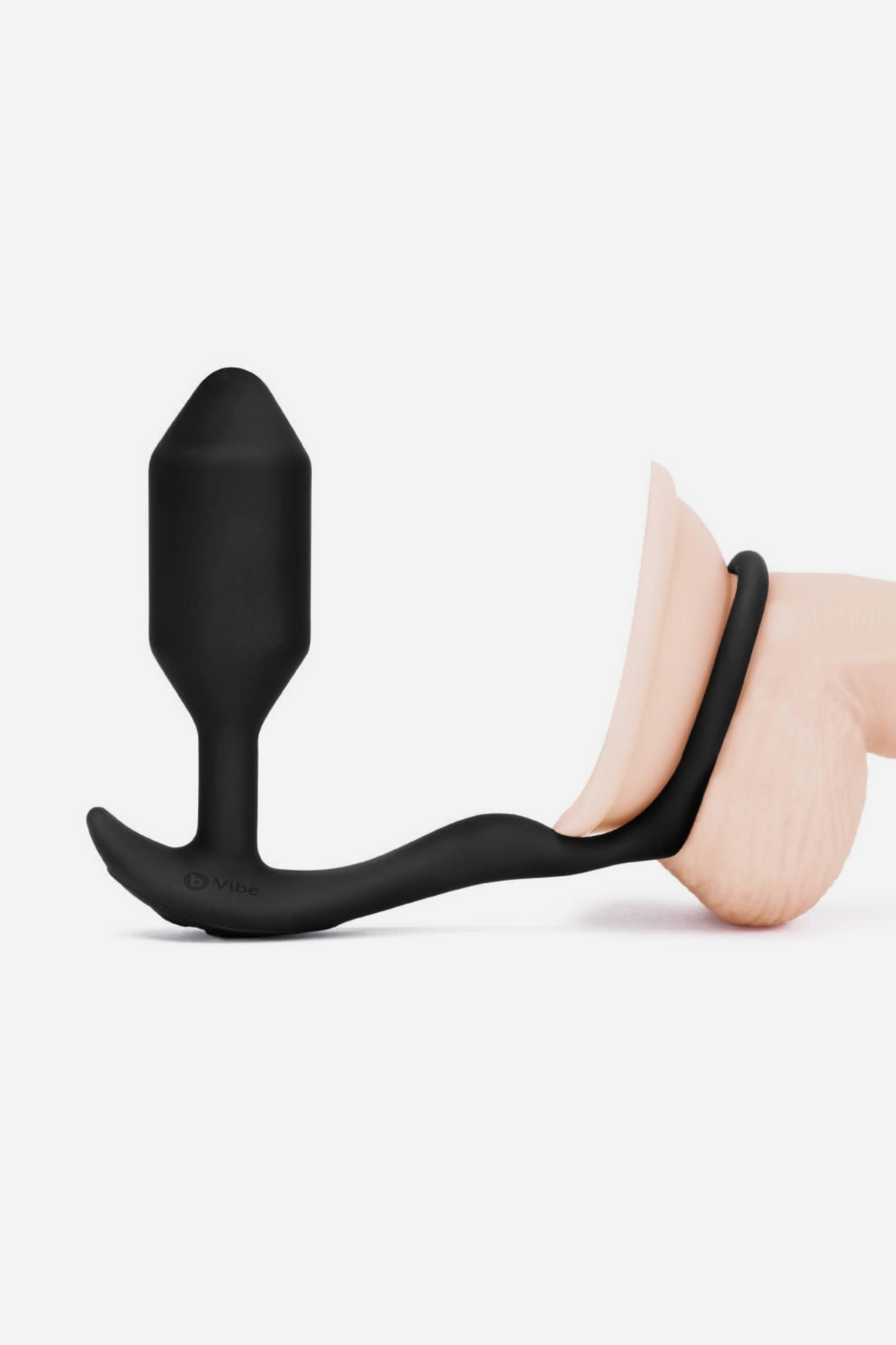B-Vibe Vibrating Snug and Tug cock ring plug shown worn on a model, with the stretchy penis ring fitted around the shaft, on grey