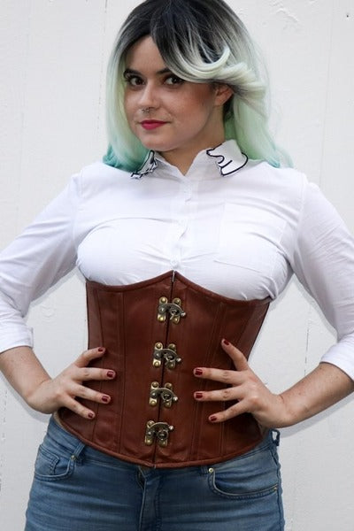 Model with teal-tipped hair wearing the Cersei natural leather underbust corset over a white button-up shirt and jeans