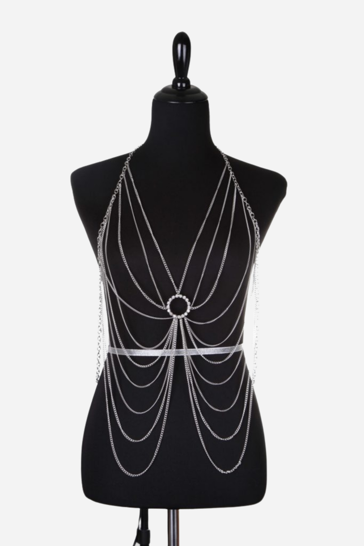 The silver chest drape shown on a black dress form, fine chains falling in looped swags from a ring at the centre above the waist.