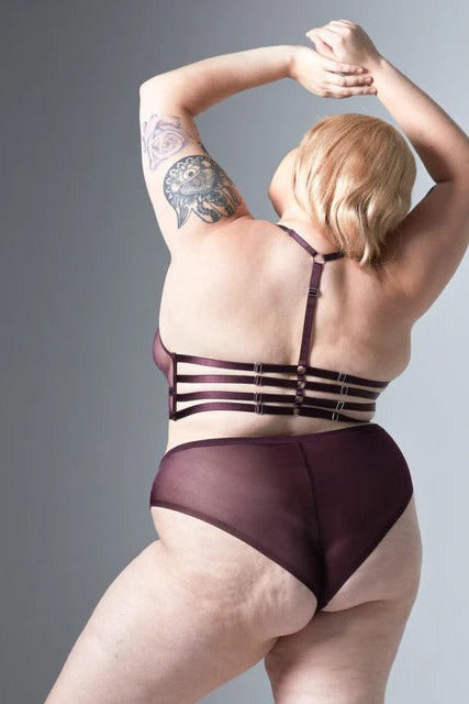 Back view of a plus-size model in the cordial Cirsi the Sorceress bikini with sheer plum mesh seat, worn with a strappy bralette