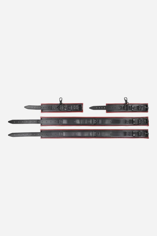 The four Crimson Spice black vegan leather cuff straps laid out flat, showing red edging, metal buckles and D-ring clip points