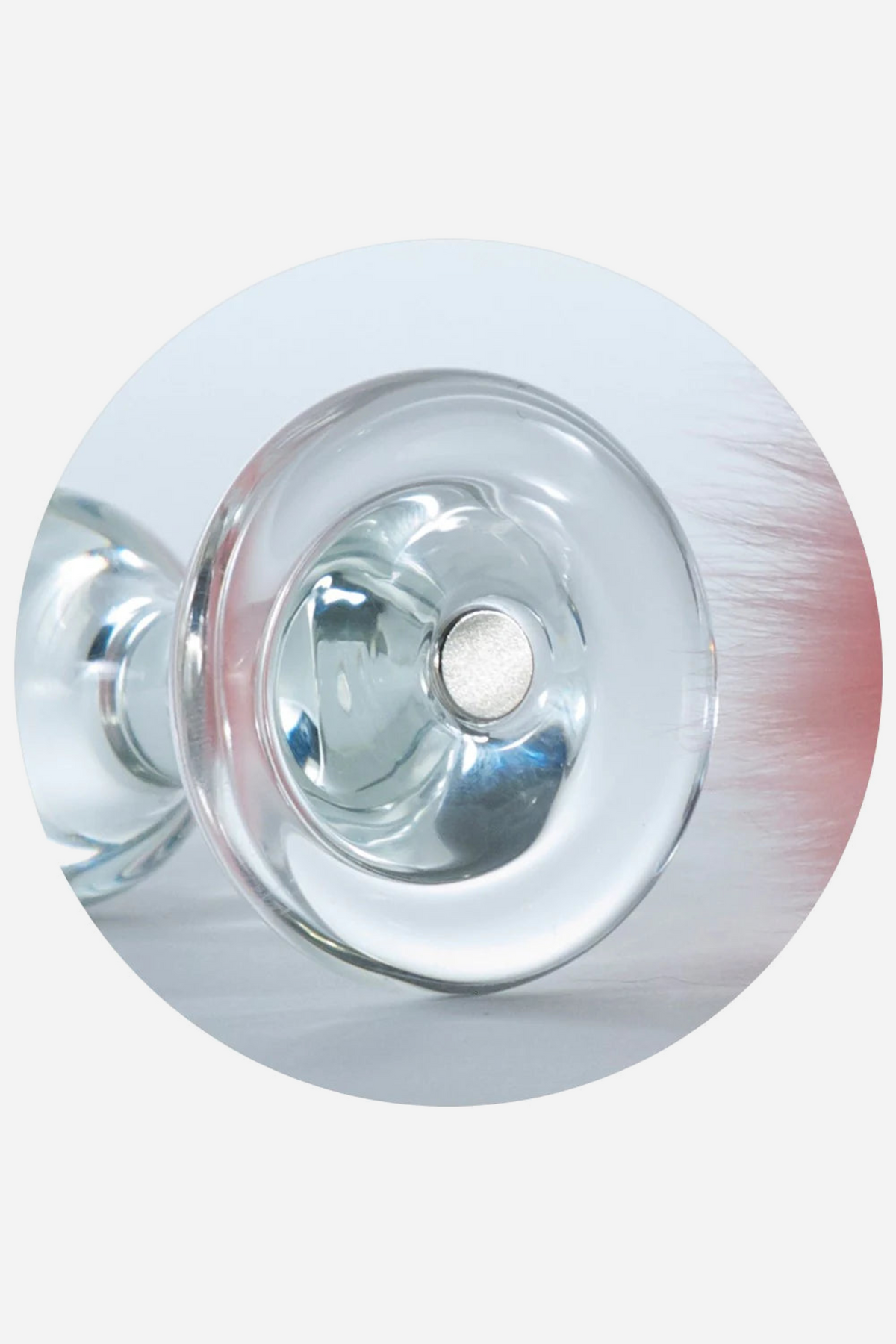 Round close-up on grey of the clear glass base of the Crystal Sparkle Plug, a silver magnet set in its centre ready for the fur tail to snap on.