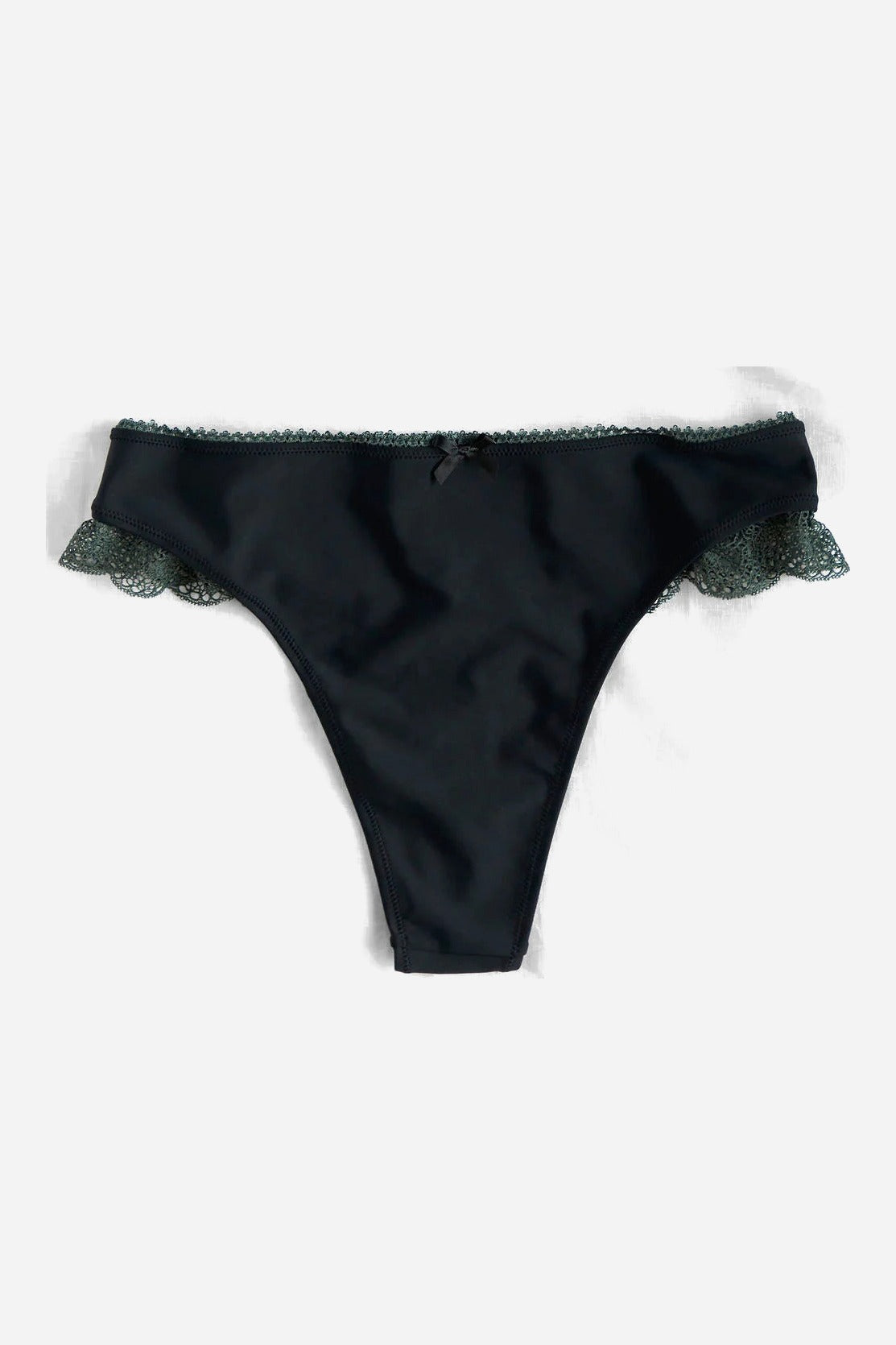 Front flat lay of the Floruisse Lucy lace thong: smooth black jersey gaff front with slate sage lace trim at the hips, on grey