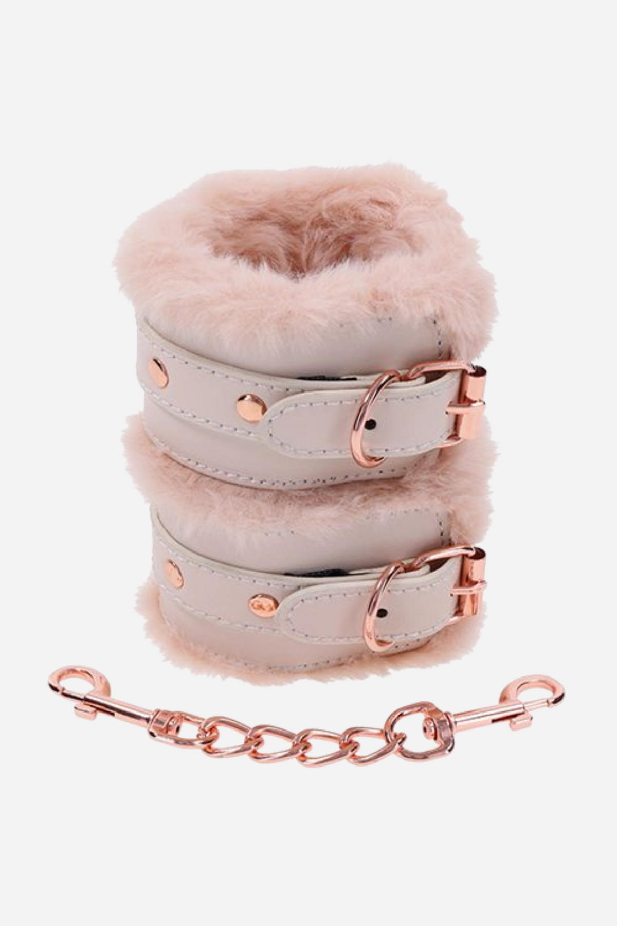 The two cuffs buckled closed and stacked one on the other, thick pale faux fur showing at the edges, with the rose gold chain coiled beneath.