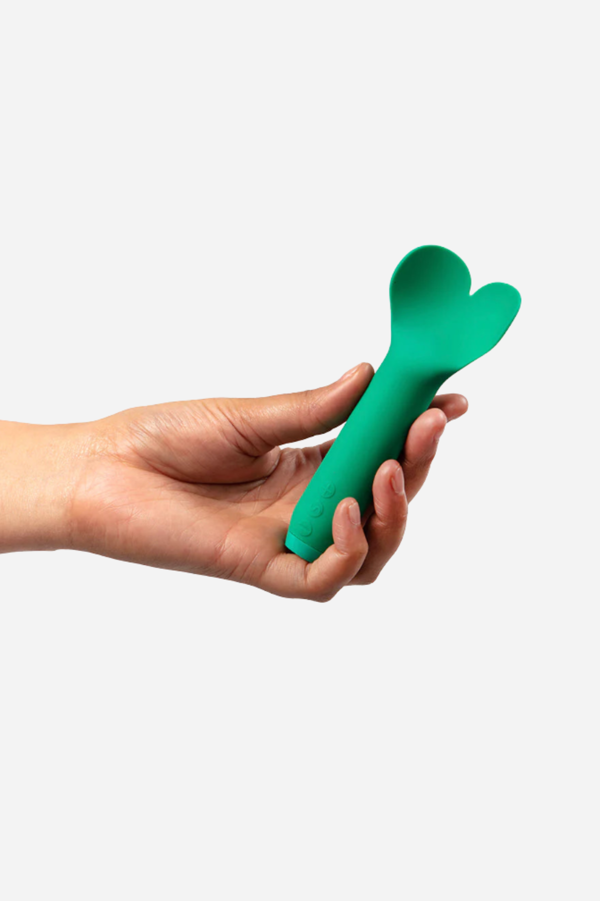 A hand holding the teal Amour flutter bullet across the open palm on grey, showing how small the toy is against the fingers and thumb.