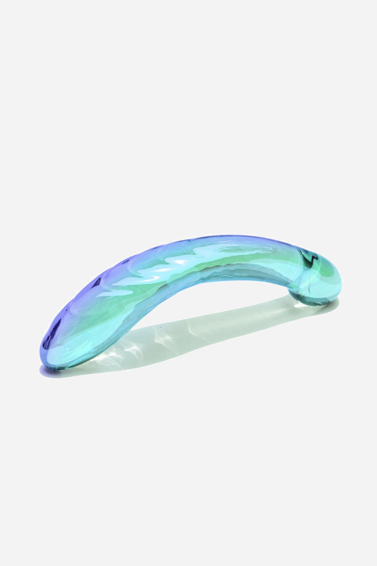 The Kalii glass wand laid on its side, showing the full curve of the shaft and the faceted ridges running along its upper edge.
