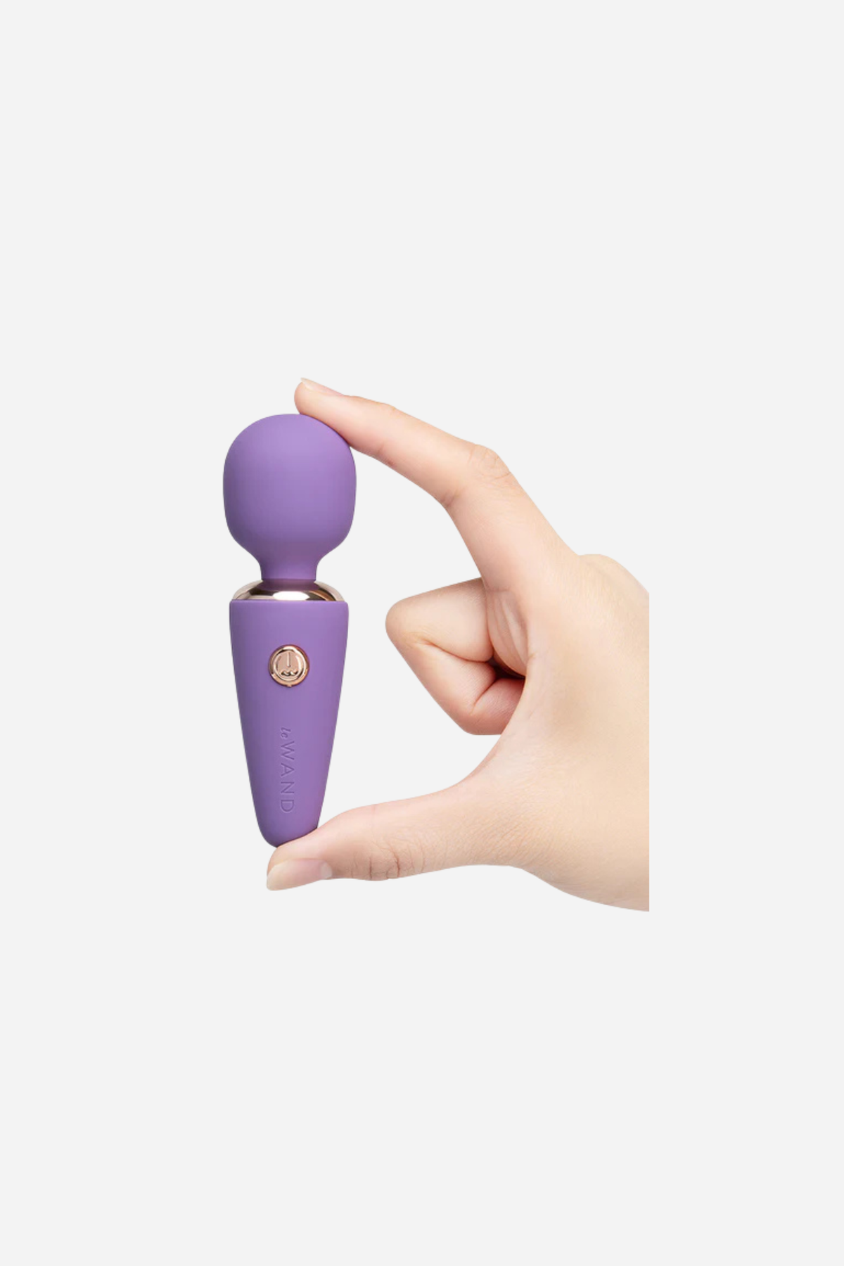 Hand holding the Le Wand Mini Micro Wand in violet between finger and thumb, showing how small this rechargeable wand massager is