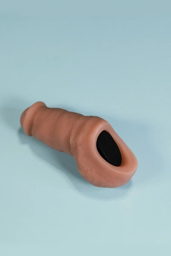Hollow silicone rod insert sleeve for the NYTC Sam STP, shown lying on a pale blue background with its black opening visible