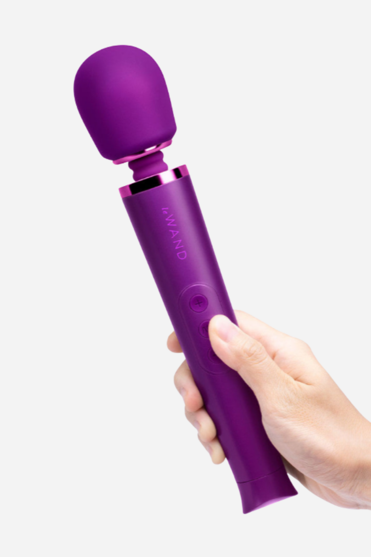 Hand holding the Le Wand Petite massager in cherry purple at an angle, showing the textured handle and flexible neck below the soft head