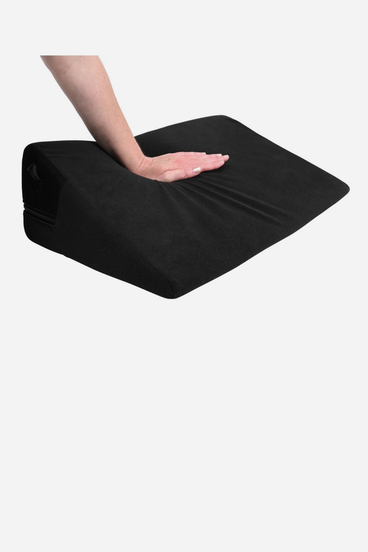 A hand pressing down on the black Pivot positioner wedge pillow on grey, showing the firm foam support beneath its soft microfibre cover.