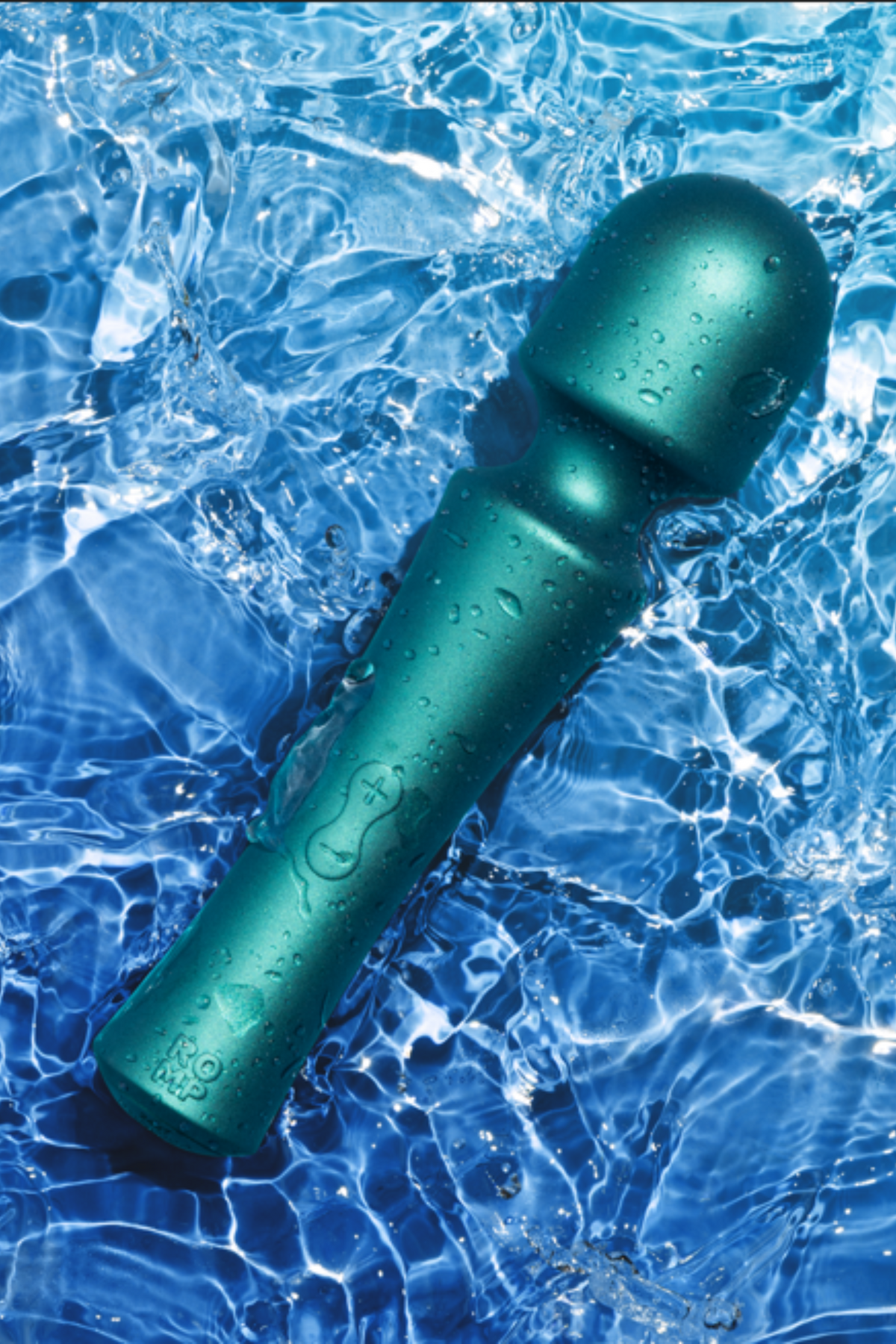 Romp Presto powerful mini wand in teal lying in clear rippling water over a blue pool background, showing its waterproof matte body