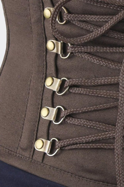 Close-up of the Princess Talulla cincher front showing antique brass clasp hooks and brown cord lacing on the topstitched twill