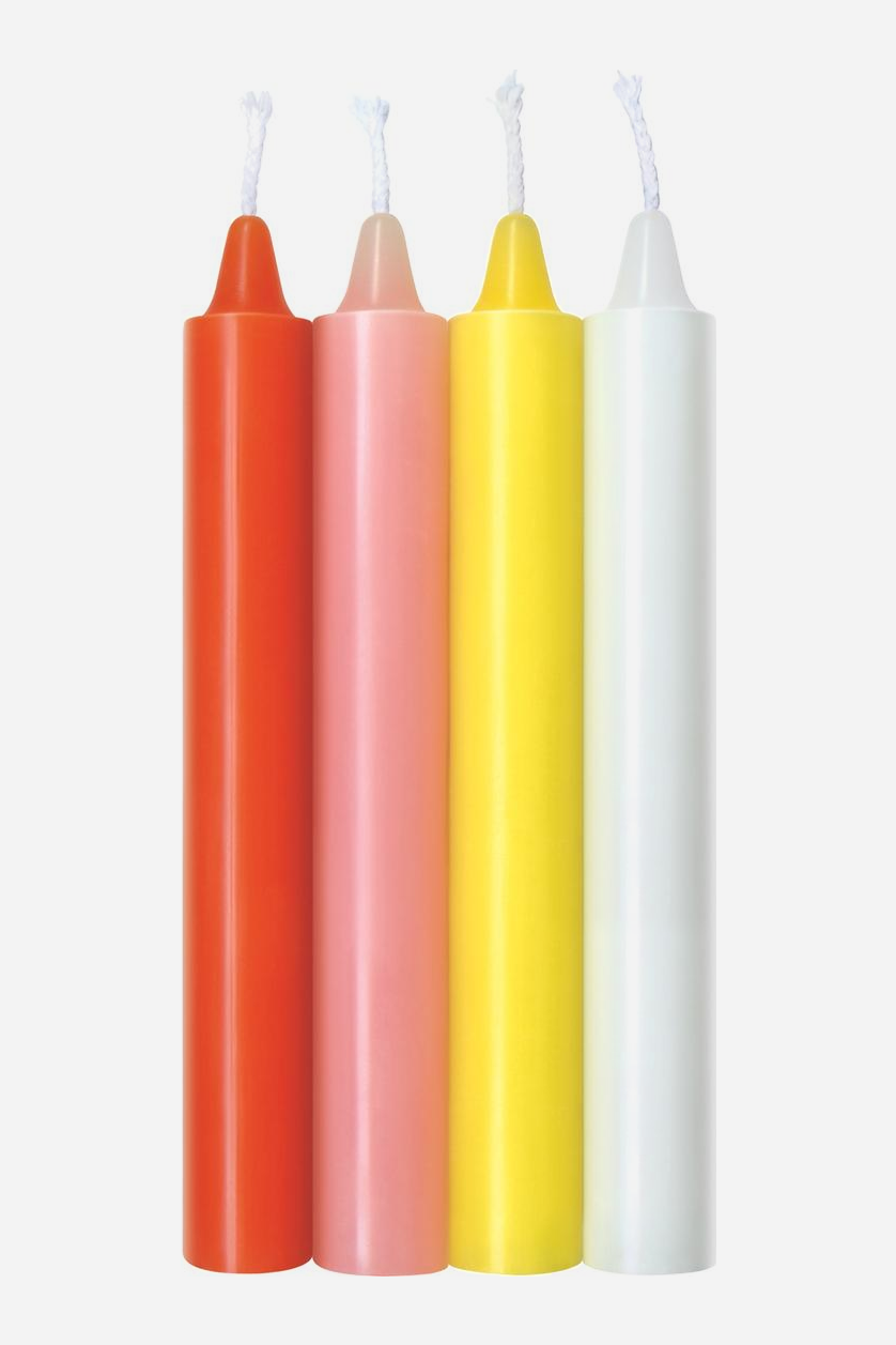 Warmth set of four tall taper wax play candles in orange, pink, yellow and white, standing side by side with their white wicks showing