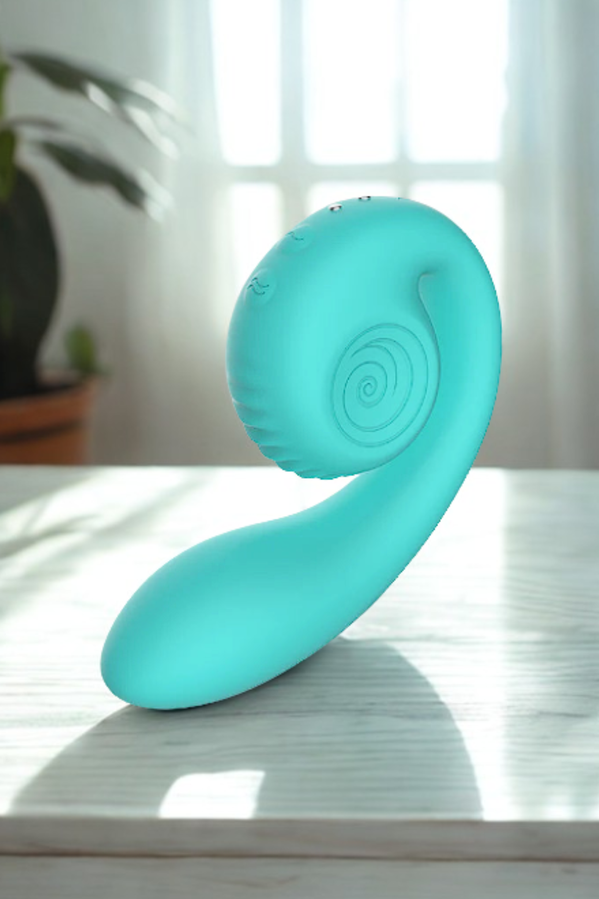 Snail Vibe Gizi rabbit vibrator in Tiffany Blue standing on a sunlit tabletop by a window, showing its spiral snail-shell design