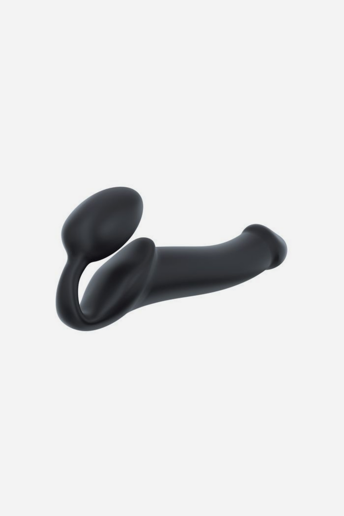 Strap-On-Me adjustable strapless dildo in black in size Large, angled view of the curved shaft and internal bulb on a light grey background