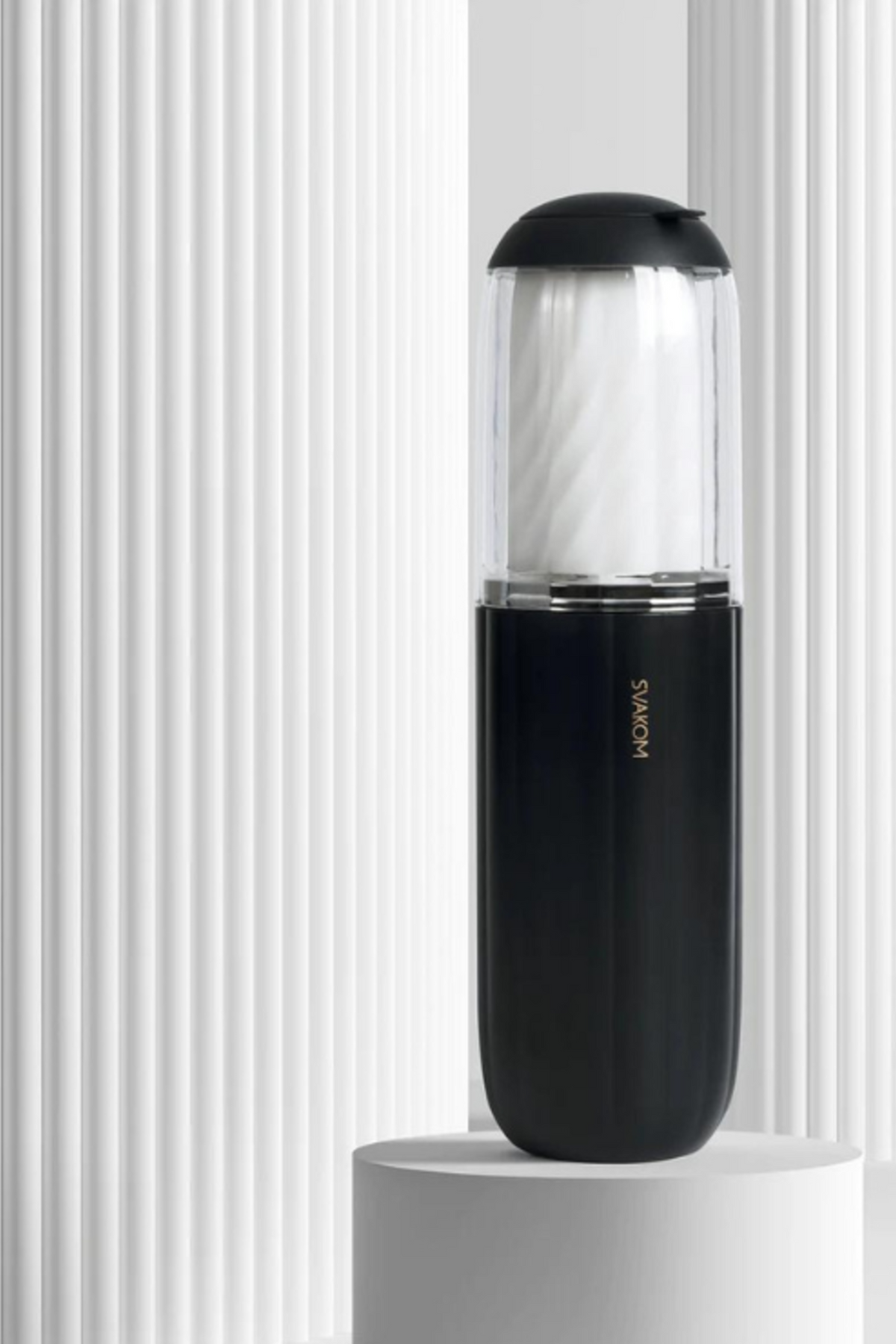 The navy Alex Neo 2 stroker displayed on a white pedestal against a fluted white backdrop