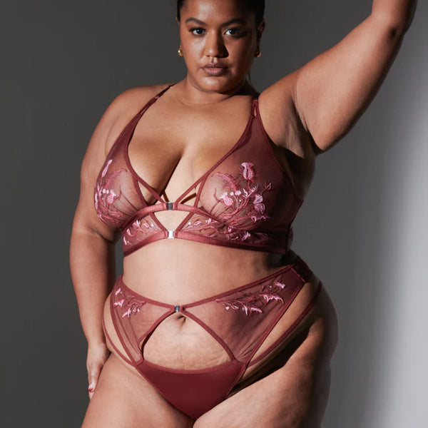 size 2x black model shows the matching set of thistle and spire cirsi bralette and thong with embroidery details and cutouts