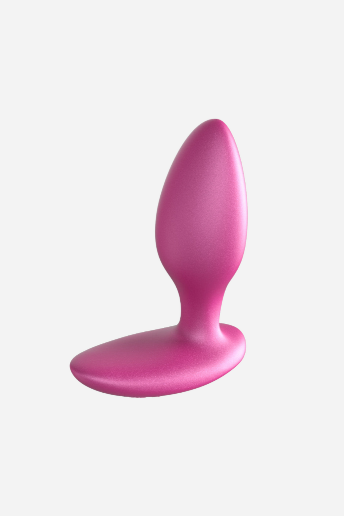 Pink We-Vibe Ditto+ plug standing upright on its base, showing the smooth tapered tip and the gentle curve of the flared base, on grey
