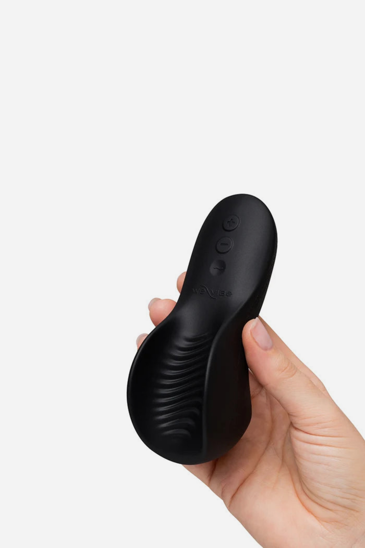 The black We-Vibe Shared Touch cradled in one hand, showing its rounded palm-sized shape with the wavy ribbed underside facing out