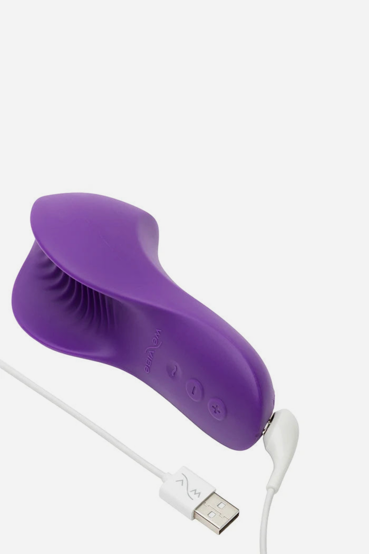 The purple We-Vibe Shared Touch connected to its white magnetic USB charging cable, lying on its side to show the curved ribbed underside