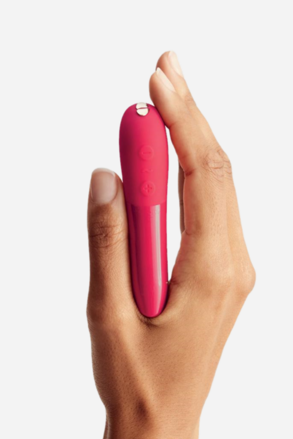 Hand holding the We-Vibe Tango X bullet vibrator in Cherry Red between the fingers, showing its compact size on light grey