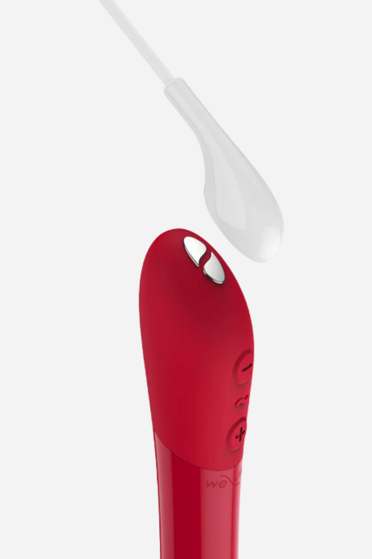 Close-up of the We-Vibe Tango X in Cherry Red with its magnetic USB charger at the tip, showing the three control buttons