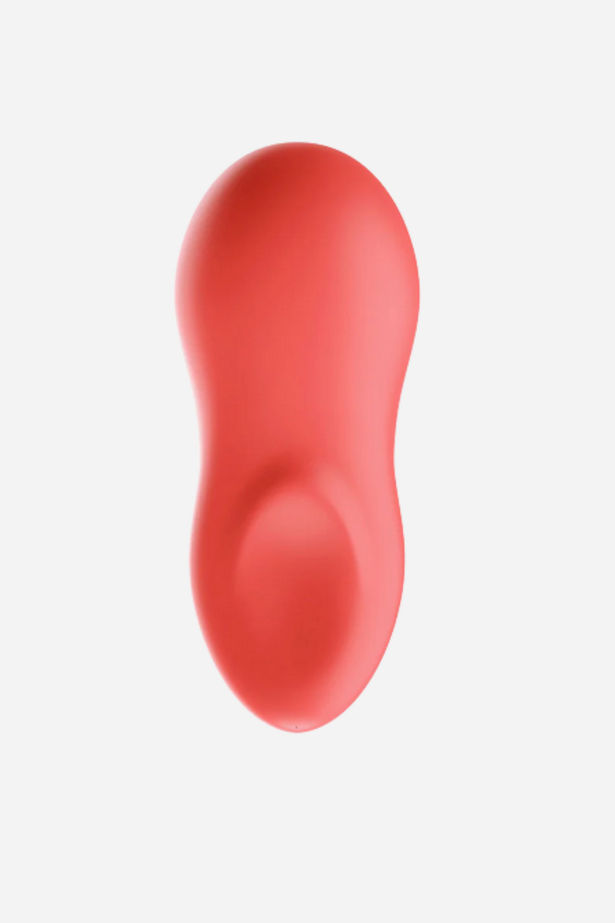 We-Vibe TouchX lay-on vibrator in coral, top view showing its curved palm-sized body and dipped fingertip-shaped tip, on light grey