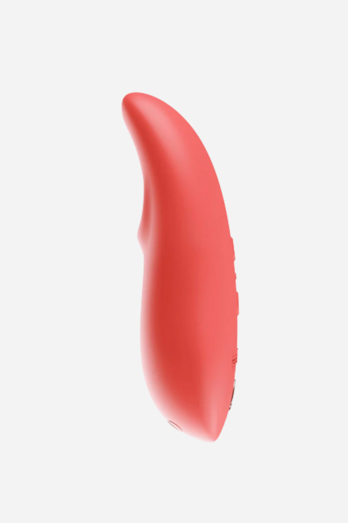 Side profile of the coral We-Vibe TouchX showing its gently curved, contoured shape and tapered tip for targeted vibration, on light grey