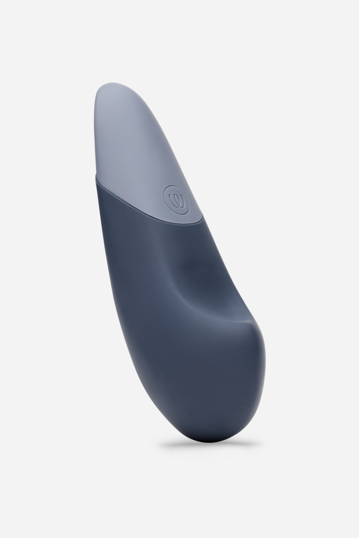 Side view of the Womanizer Vibe in dark blue, showing its gently curved pebble shape and tapered grey tip for precise external stimulation