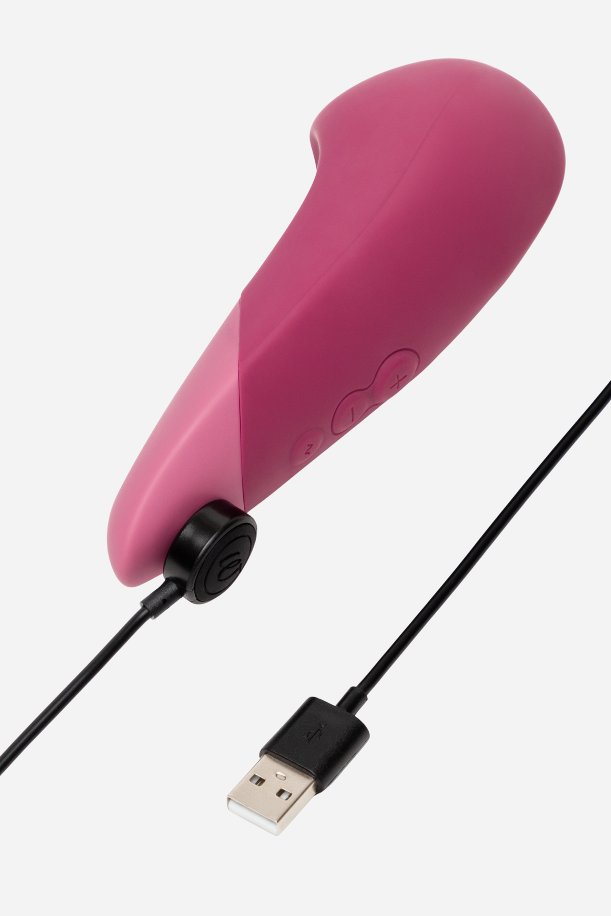 Dusty pink Womanizer Vibe with its black magnetic USB charging cable clipped to the base, showing how easily the toy recharges between uses