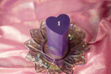 purple heart shaped wax play candle on pink fabric