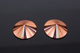 shiny rose gold metal pasties on a dark background