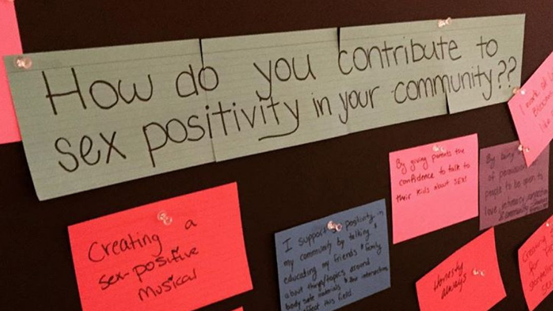 Corkboard display with cards reading "How do you contribute to sex positivity in your community?"