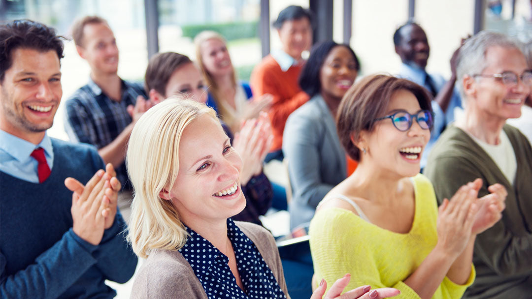 Group of workshop participants smiling and applauding
