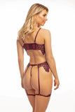 blonde model in size small stands facing away from camera to show off the g-string panty and garter straps on her burgundy red lingerie set