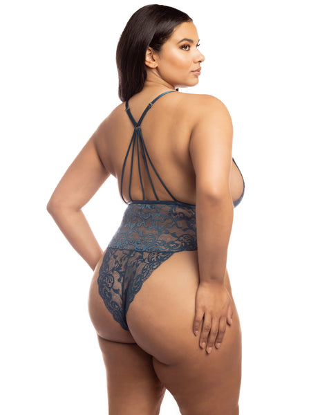 plus size model turns away from the camera to show off the strappy razor-back look of the back of the bodysuit. the bottom of the bodysuit is a cheeky cut that has moderate coverage- showing off the booty