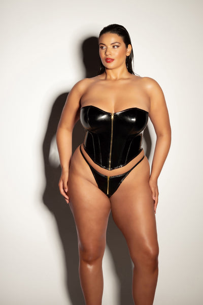 sexy plus size model with slicked back hair wearing a strapless fetish corset  with matching panty