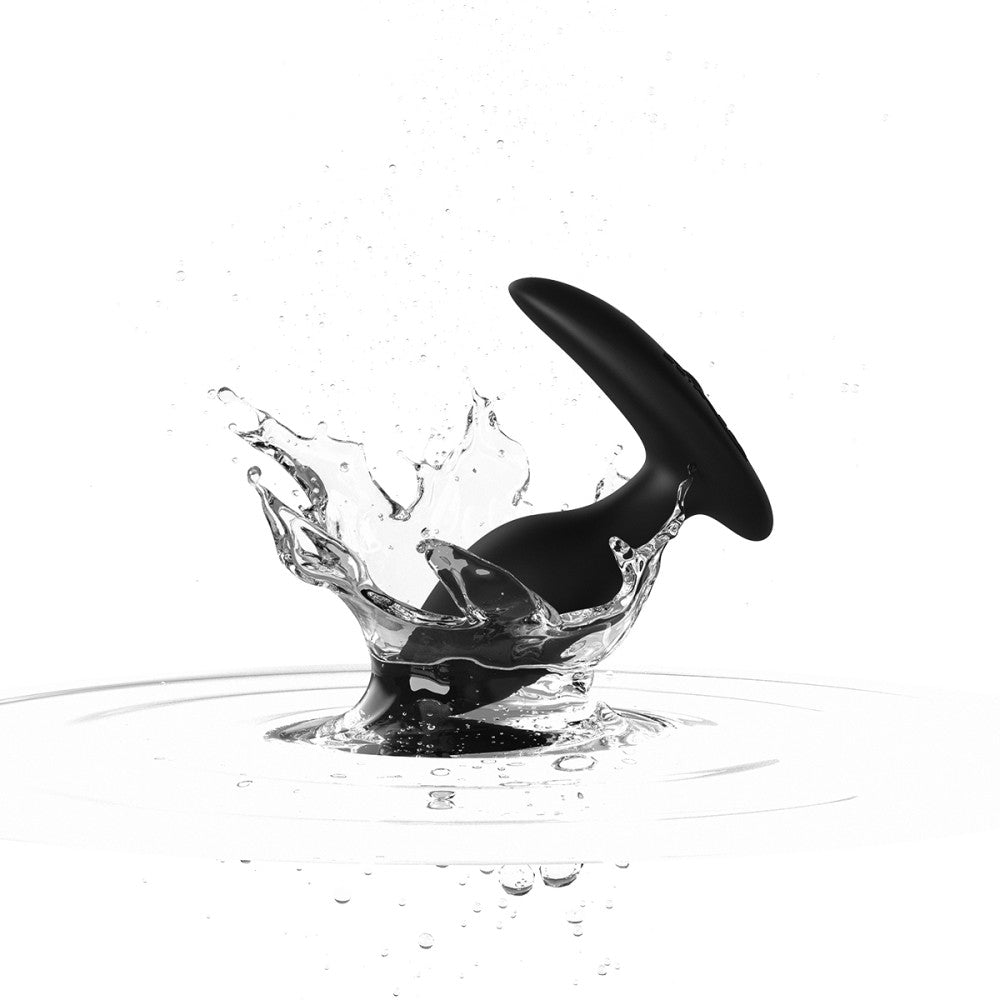 black silicone butt plug splashes in water to show that the toy is waterproof