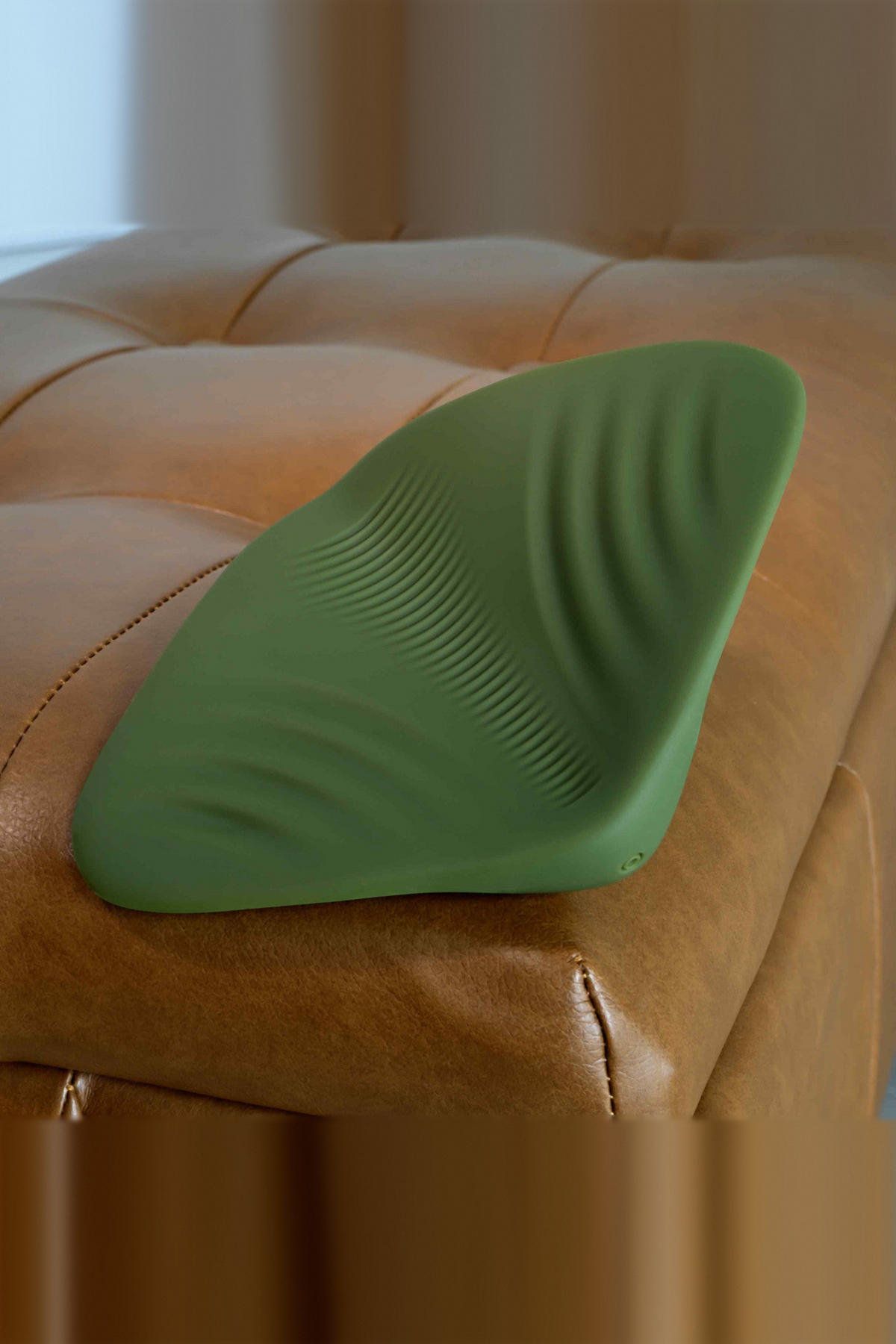 Close-up of the All the Pleasure grinding pad in Olive Green on leather, showing the fine ribbed texture across its raised ridge