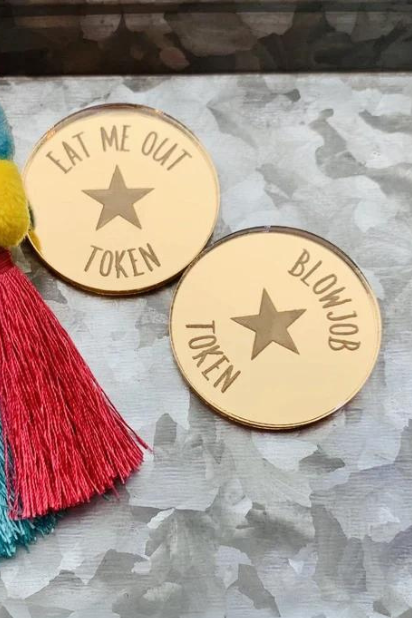 Photo of example gold mirror acrylic Sexy Time Tokens reading Eat Me Out and Blowjob on metal with tassels; each token is sold separately