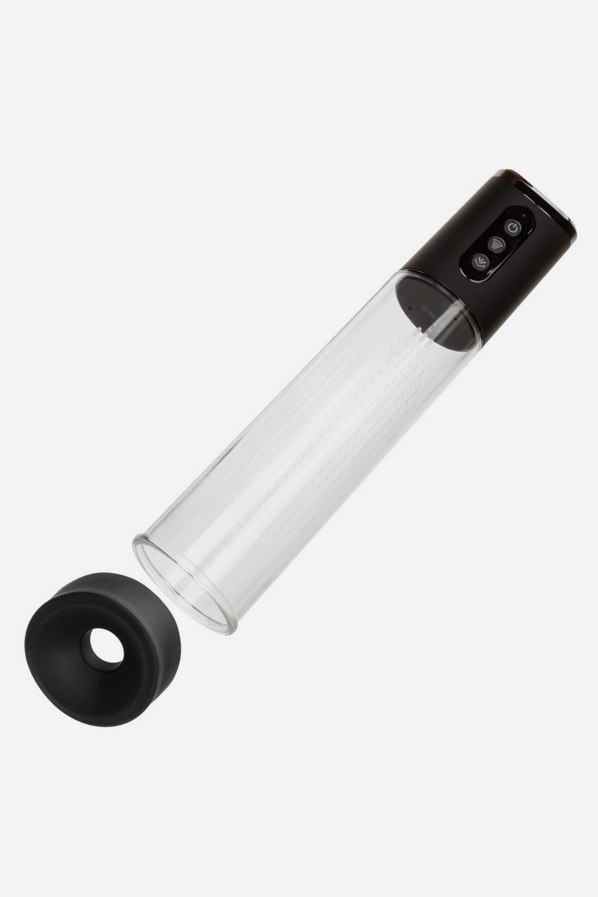 At Your Peak rechargeable penis pump lying at an angle with the removable silicone donut detached from the cylinder, on light grey