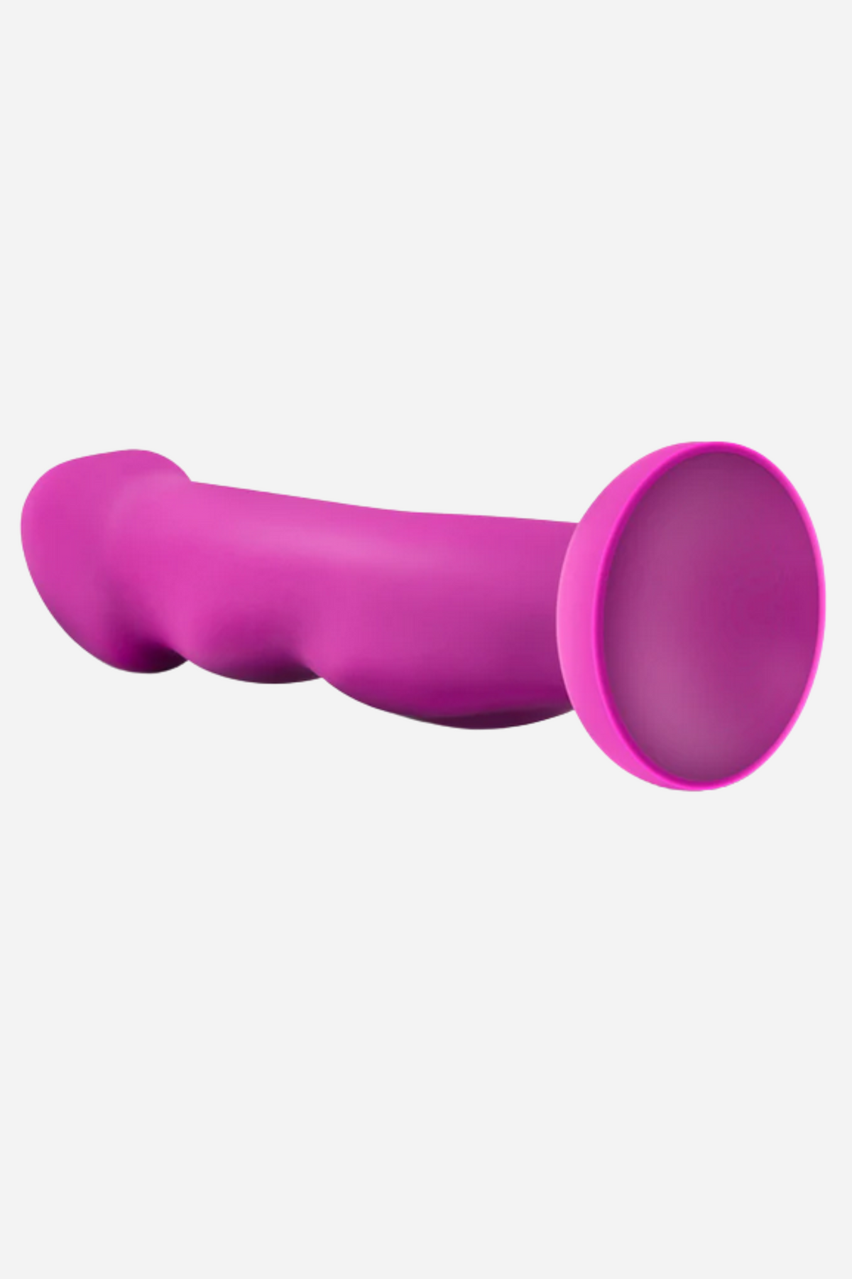 A side view of the magenta dildo lying across the frame, showing the sculpted head, the ridged shaft and the flat round suction base.