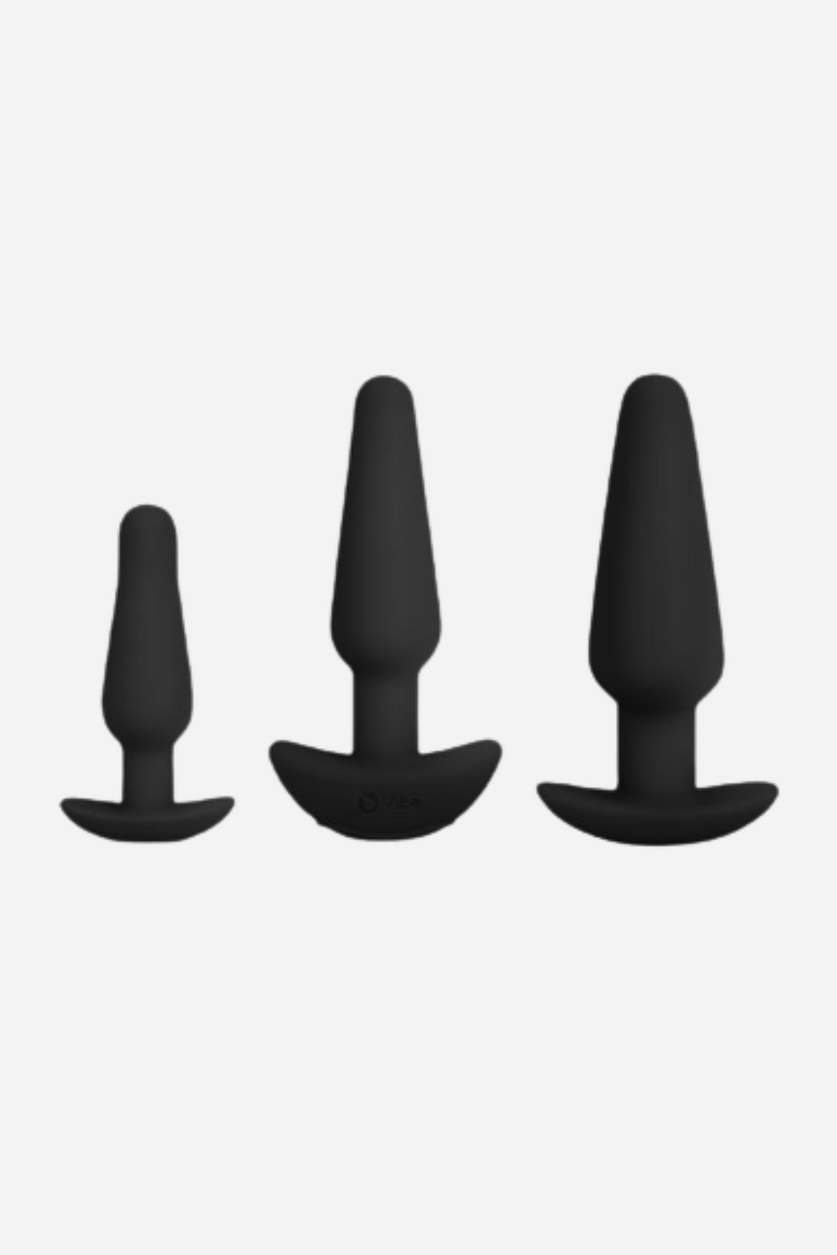 B-Vibe anal training plug set in Black, showing the three graduated small, medium and large silicone plugs side by side on grey