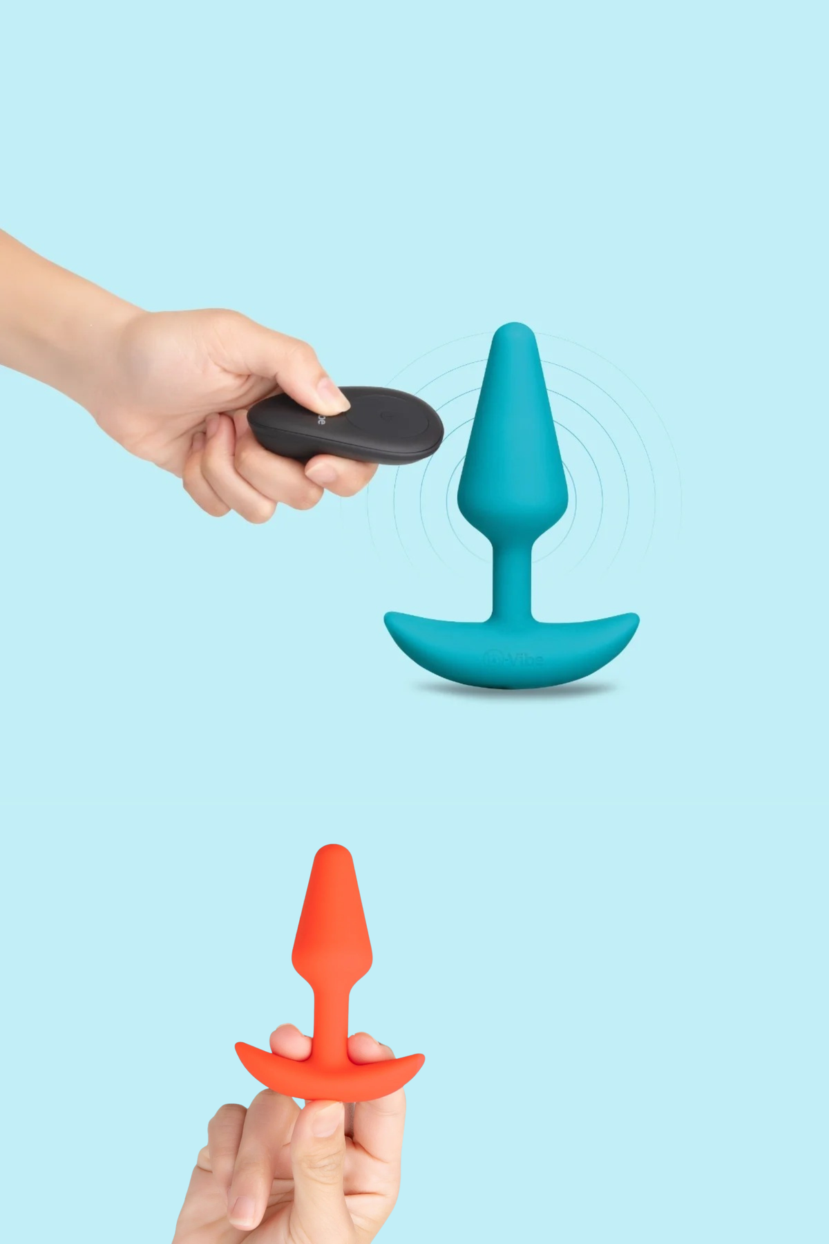 Hands holding the remote above the teal vibrating plug and the orange beginner plug from the B-Vibe Intro Anal Training Kit, on blue