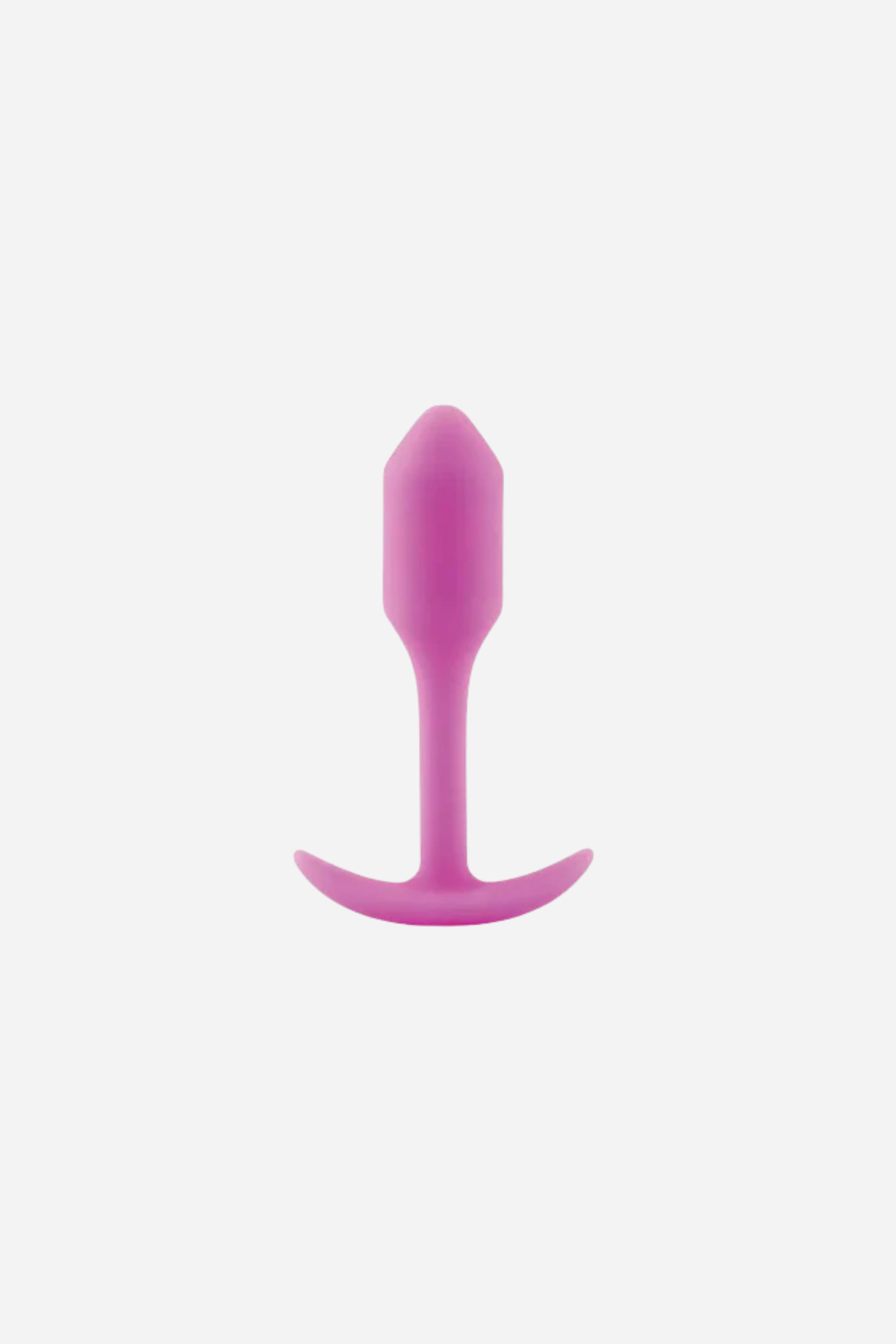 B-Vibe Snug Plug 1 small weighted butt plug in pink, with a tapered tip, slim neck and flared T-bar base, shown upright on light grey