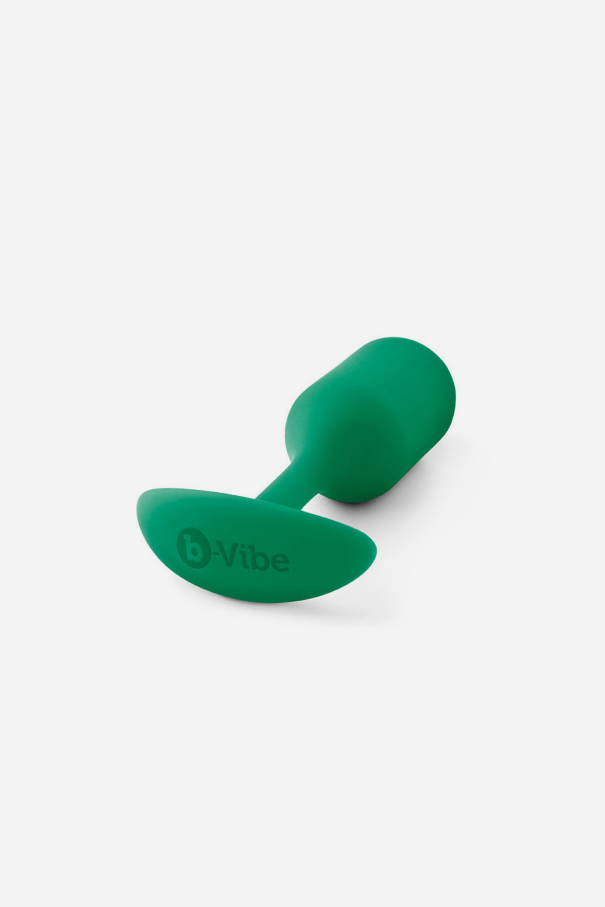 Green B-Vibe Snug Plug 2 lying on its side, showing the embossed B-Vibe logo on the curved base and the rounded weighted bulb, on grey